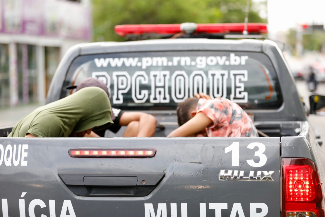 Suspeitos presos na carroceria de uma viatura da Polícia Militar