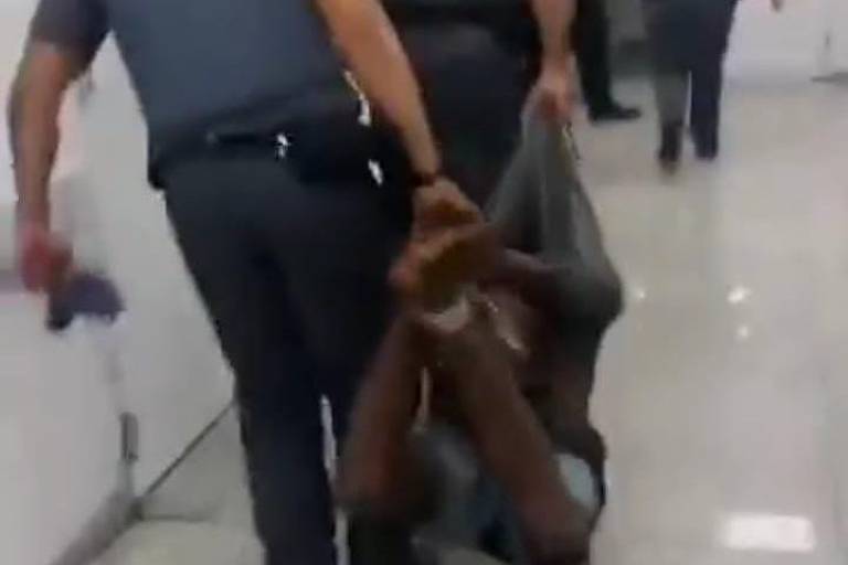 Homem negro tem pés e mãos amarrados e é carregado por policiais em SP